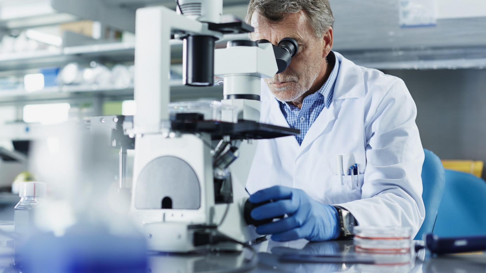Scientist looking through microscope in research laboratory